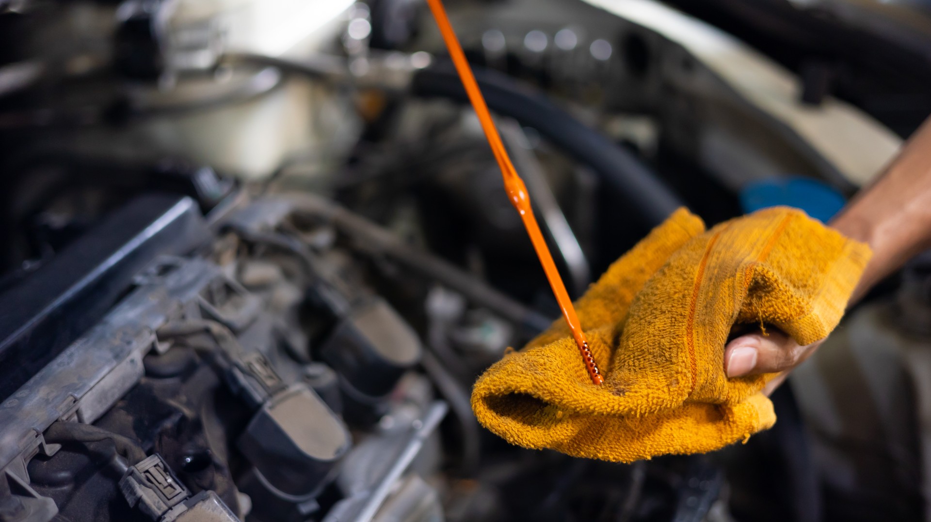 Closeup hand and spanner. Auto car mechanic checking the oil level of the car engine.